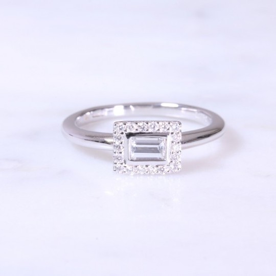 A contemporary horizontal baguette cut diamond set surround with round brilliant cuts in a halo ring