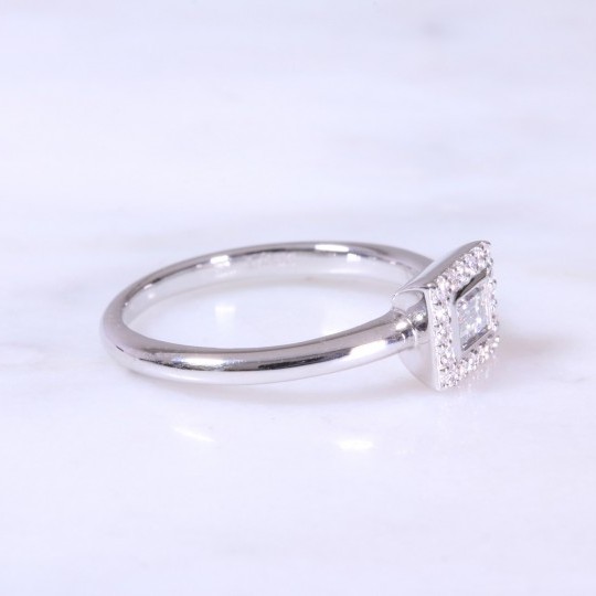 A contemporary horizontal baguette cut diamond set surround with round brilliant cuts in a halo ring